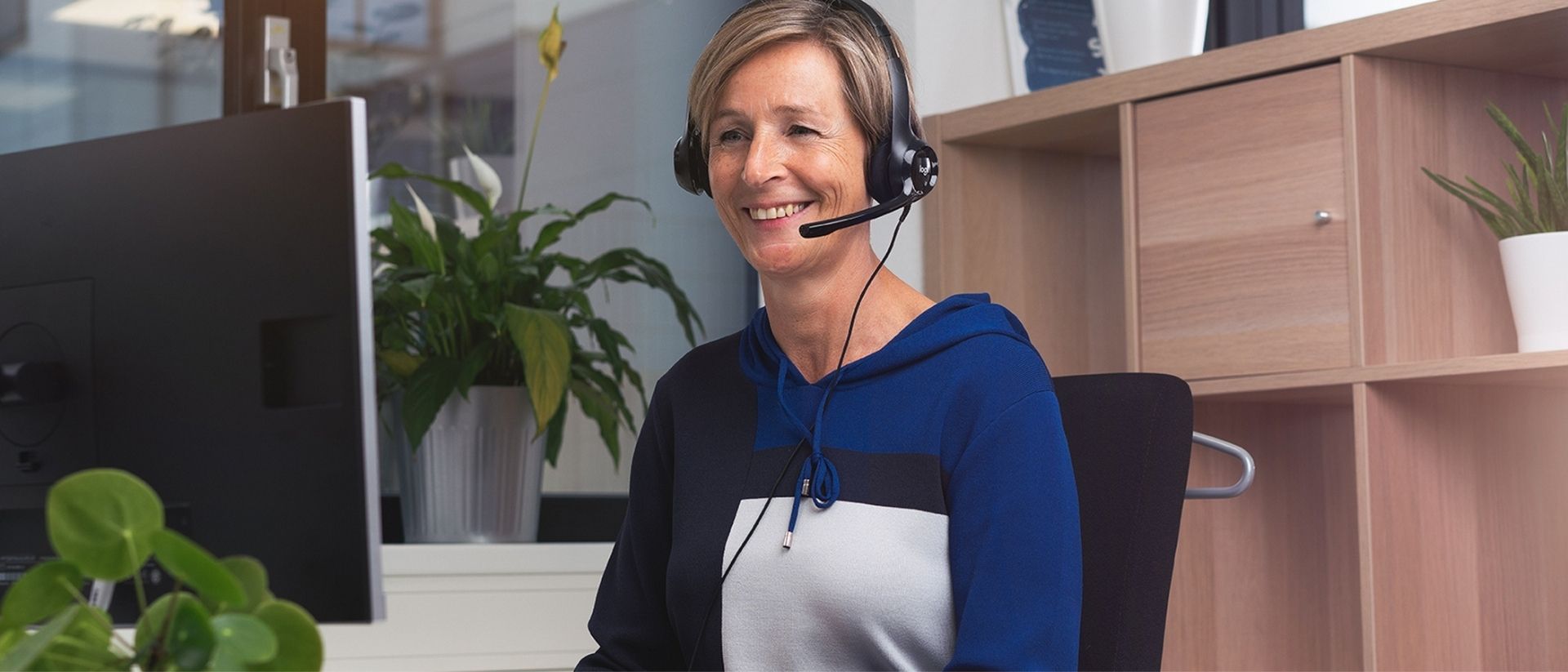 Vrouw met headset achter computer