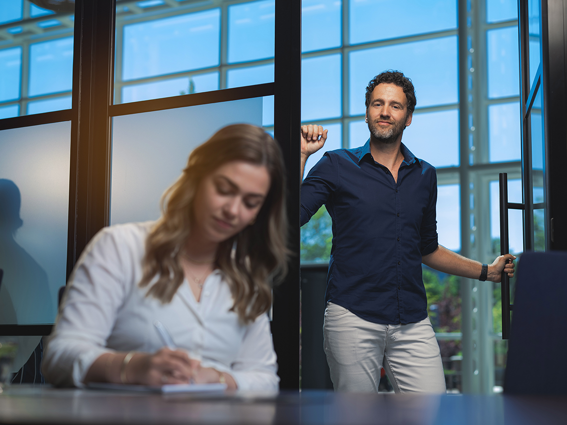 Medewerkster aan het werk met manager in deuropening